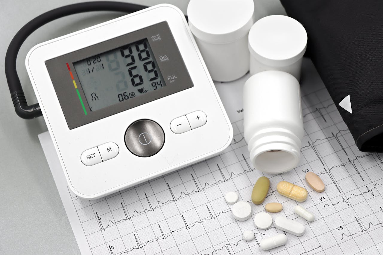 about-01 Blood pressure monitor with pills on ECG sheet, essential for heart health management.